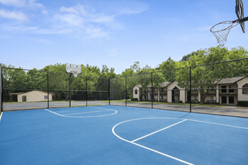 Outdoor basketball court with fenced perimeter